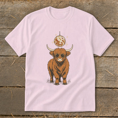 Highland cow wearing sunglasses with disco ball above on pink t-shirt.