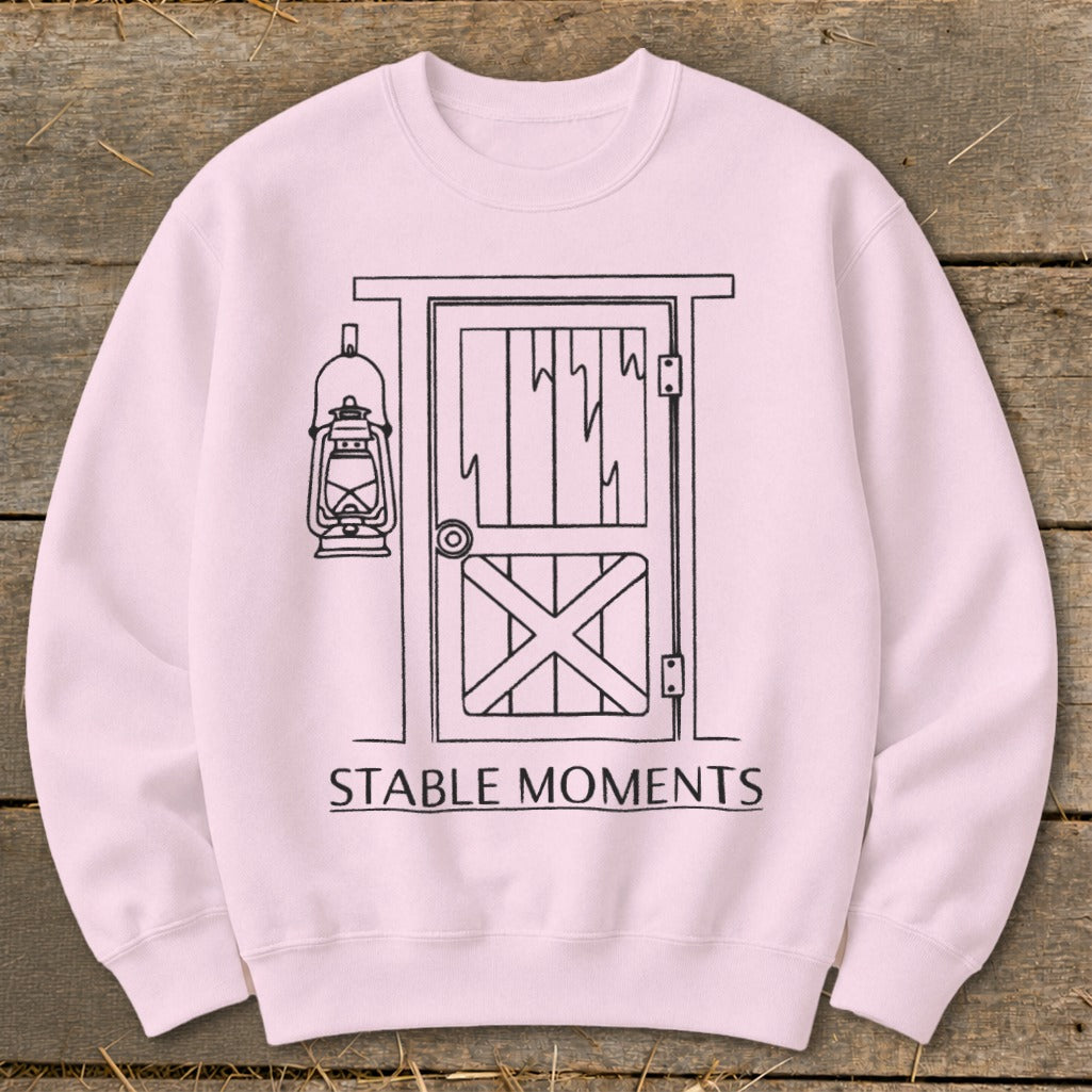 Pink sweatshirt with line drawing of barn door, lantern, and text "STABLE MOMENTS".