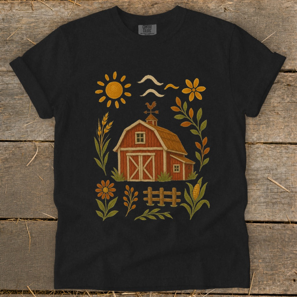 Black t-shirt with a rustic farm graphic featuring a barn, sun, and flowers.