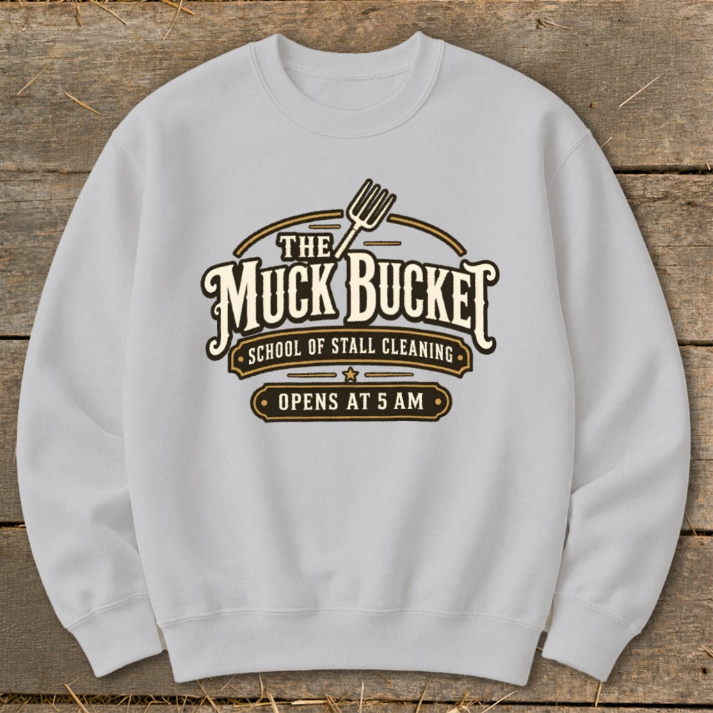 Light grey sweatshirt with "The Muck Bucket School of Stall Cleaning Opens at 5 AM" logo.