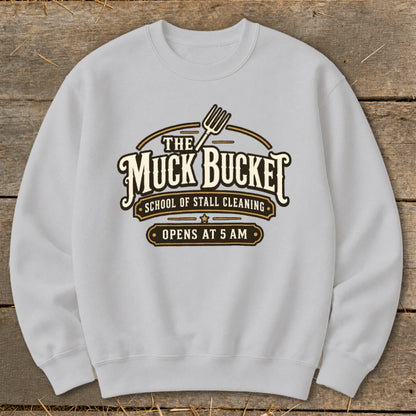 Light grey sweatshirt with "The Muck Bucket School of Stall Cleaning Opens at 5 AM" logo.