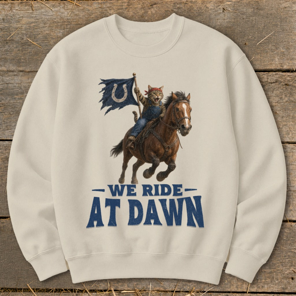Cat riding a horse, holding a tattered flag with a horseshoe, text says "We Ride At Dawn."