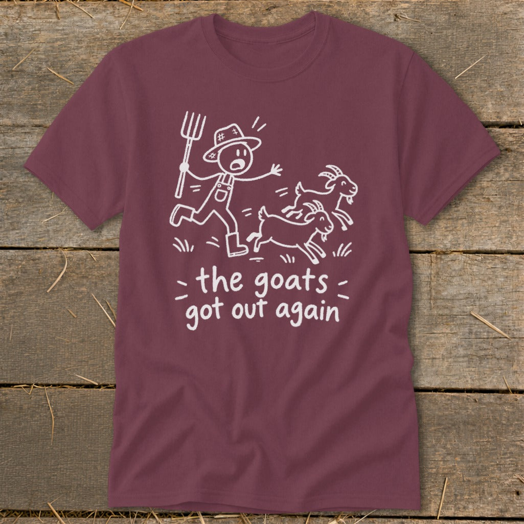 Maroon t-shirt with white cartoon of a farmer chasing goats and text "the goats got out again."