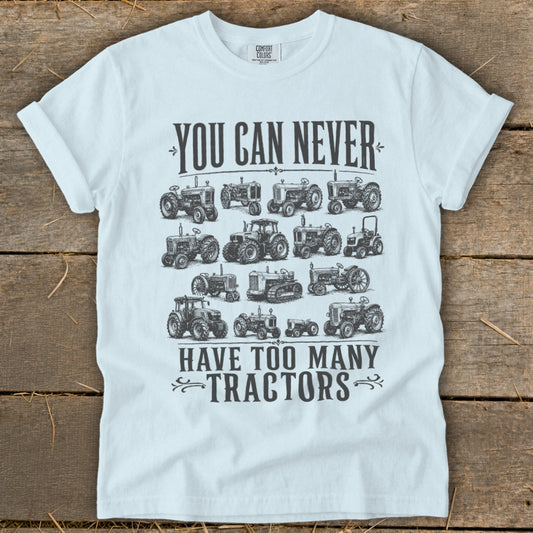 White t-shirt with vintage tractors and text "YOU CAN NEVER HAVE TOO MANY TRACTORS".