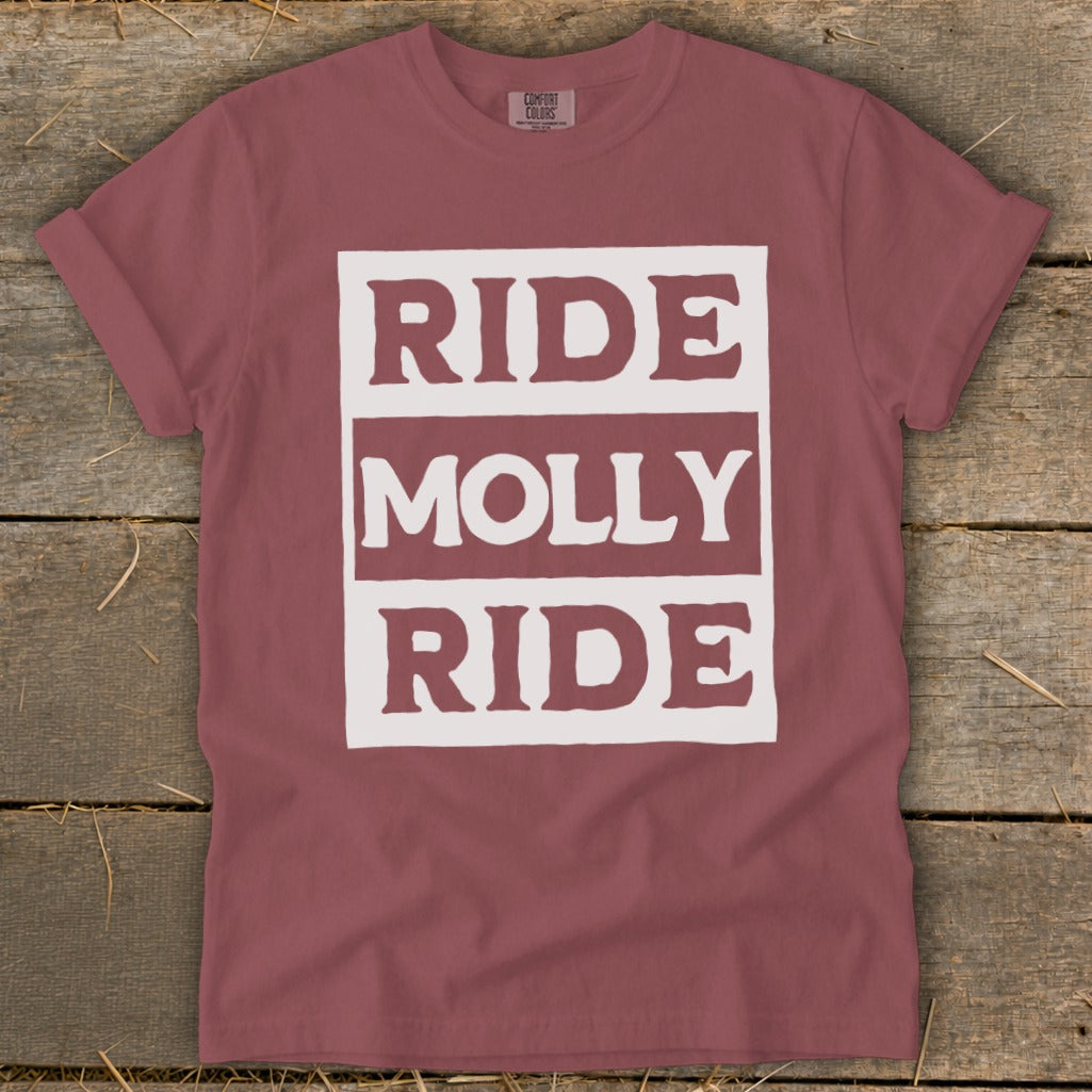 A dusty rose t-shirt features a white rectangular graphic on the chest with the text "RIDE MOLLY RIDE" in bold, distressed block lettering.