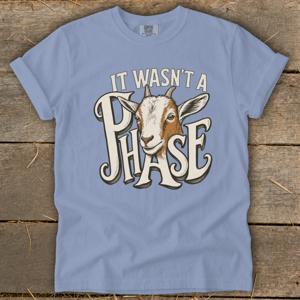 Light blue t-shirt with a graphic of a goat and text that reads "IT WASN'T A PHASE".