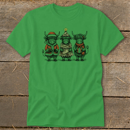 Three highland cows in Christmas attire stand together on a green t-shirt.