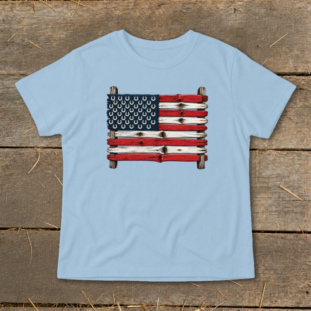 Light blue short-sleeved t-shirt featuring a graphic of the American flag made from weathered wooden planks and horseshoes.