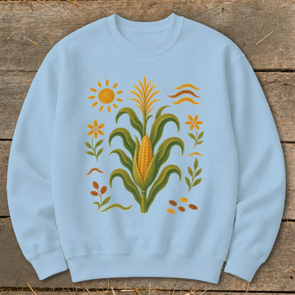 Light blue sweatshirt with embroidered corn, sun, flowers, and leaves design.