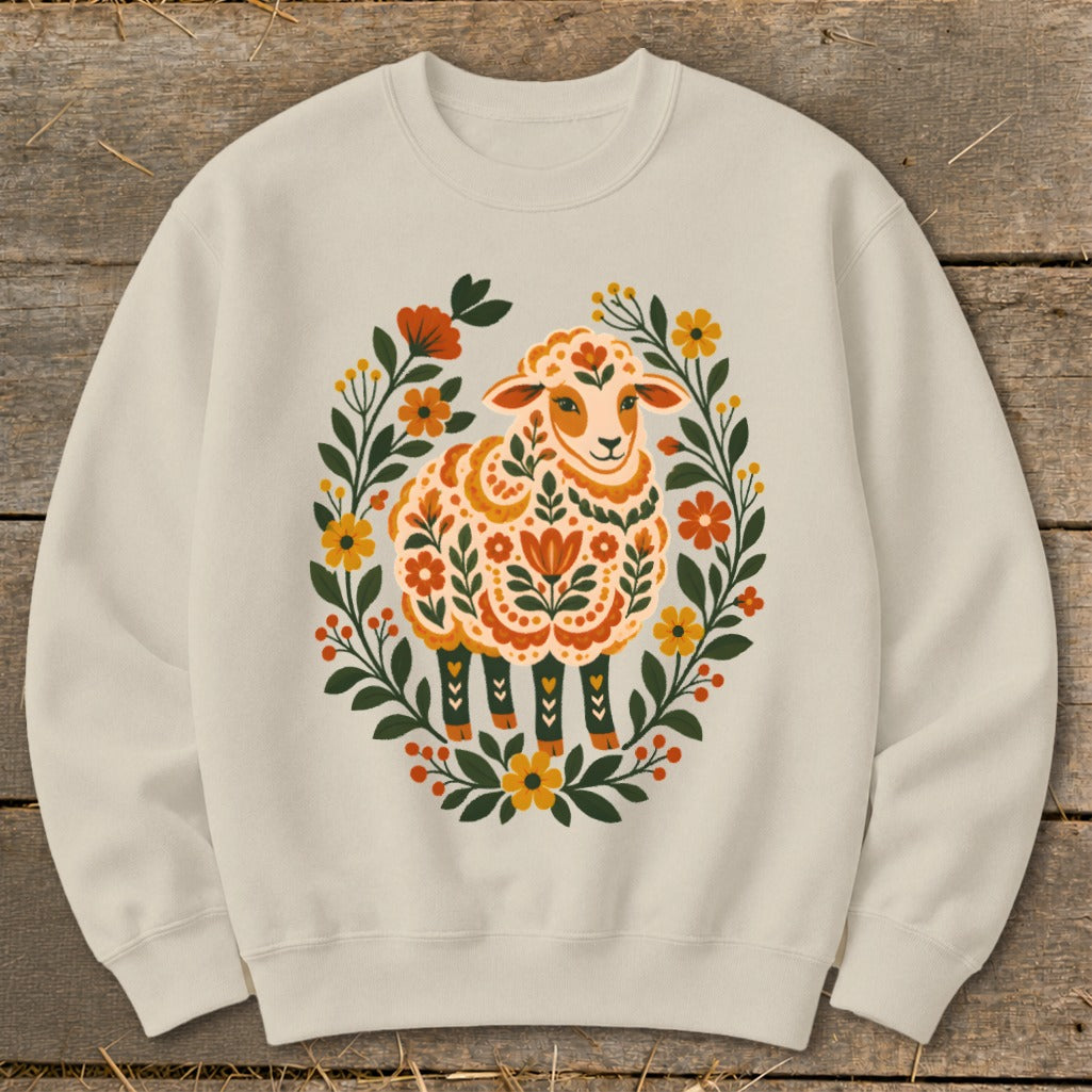 Cream sweatshirt with a folk art sheep surrounded by a floral wreath.
