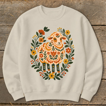 Cream sweatshirt with a folk art sheep surrounded by a floral wreath.
