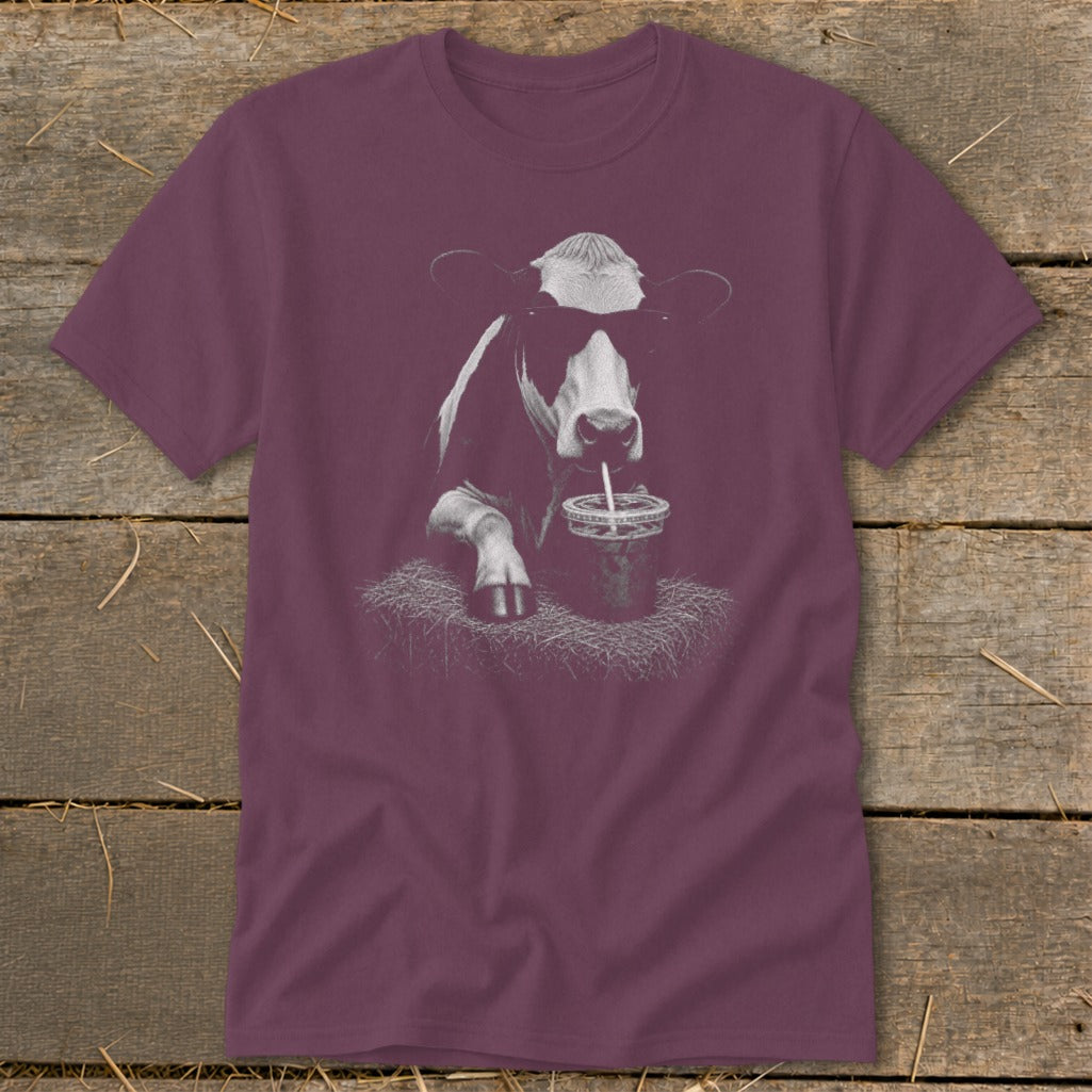 T-shirt with a graphic of a cow wearing sunglasses drinking from a cup.