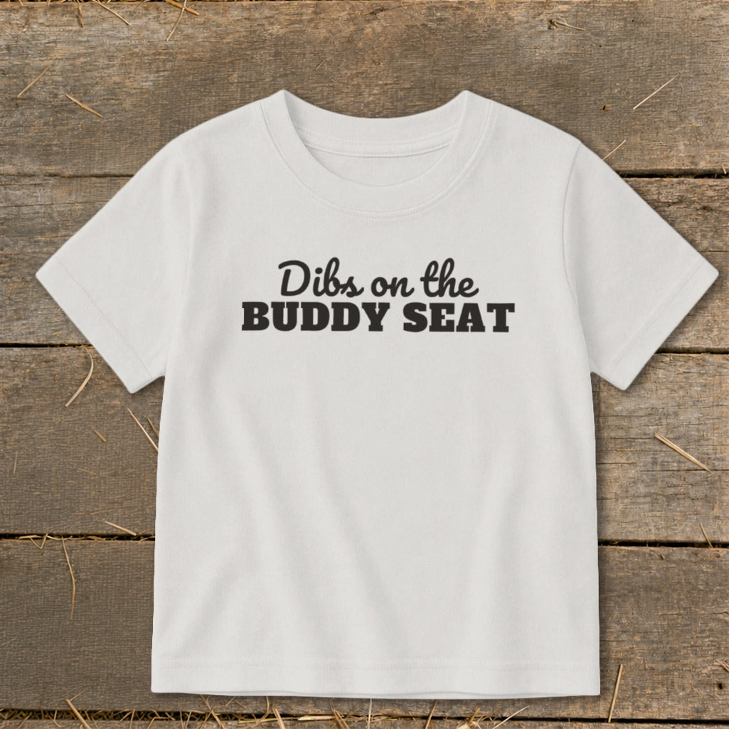 White t-shirt with black text "Dibs on the BUDDY SEAT"