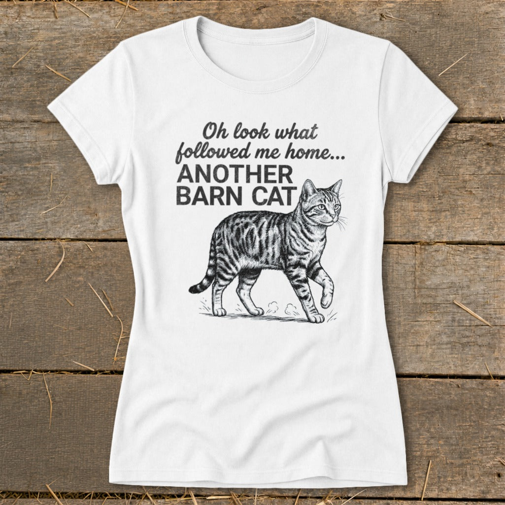 White t-shirt with black text and barn cat illustration reading "Oh look what followed me home... ANOTHER BARN CAT".