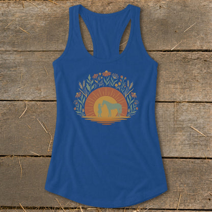 Blue tank top with a graphic of a person and horse at sunset surrounded by flowers.
