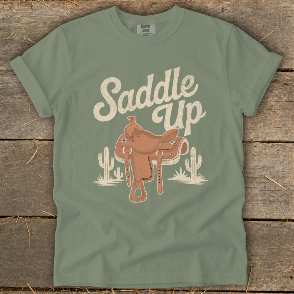 Green t-shirt with "Saddle Up" text and a cowboy saddle graphic.