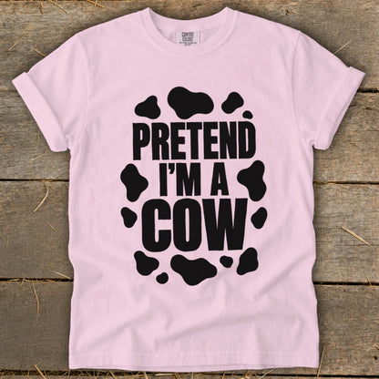 Pink t-shirt with black cow spots and text "PRETEND I'M A COW".