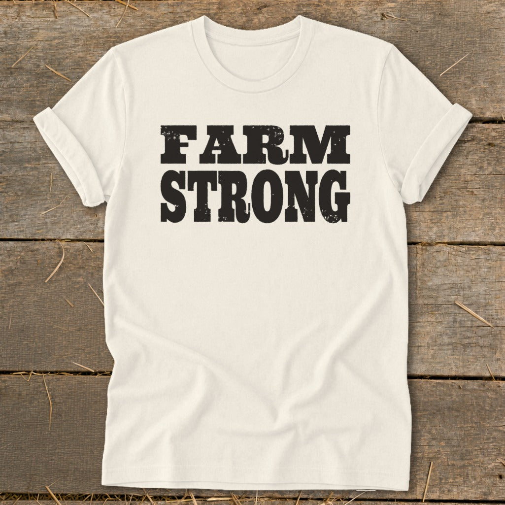 Off-white crewneck t-shirt with rolled sleeves featuring the bold black text FARM STRONG displayed across the chest.