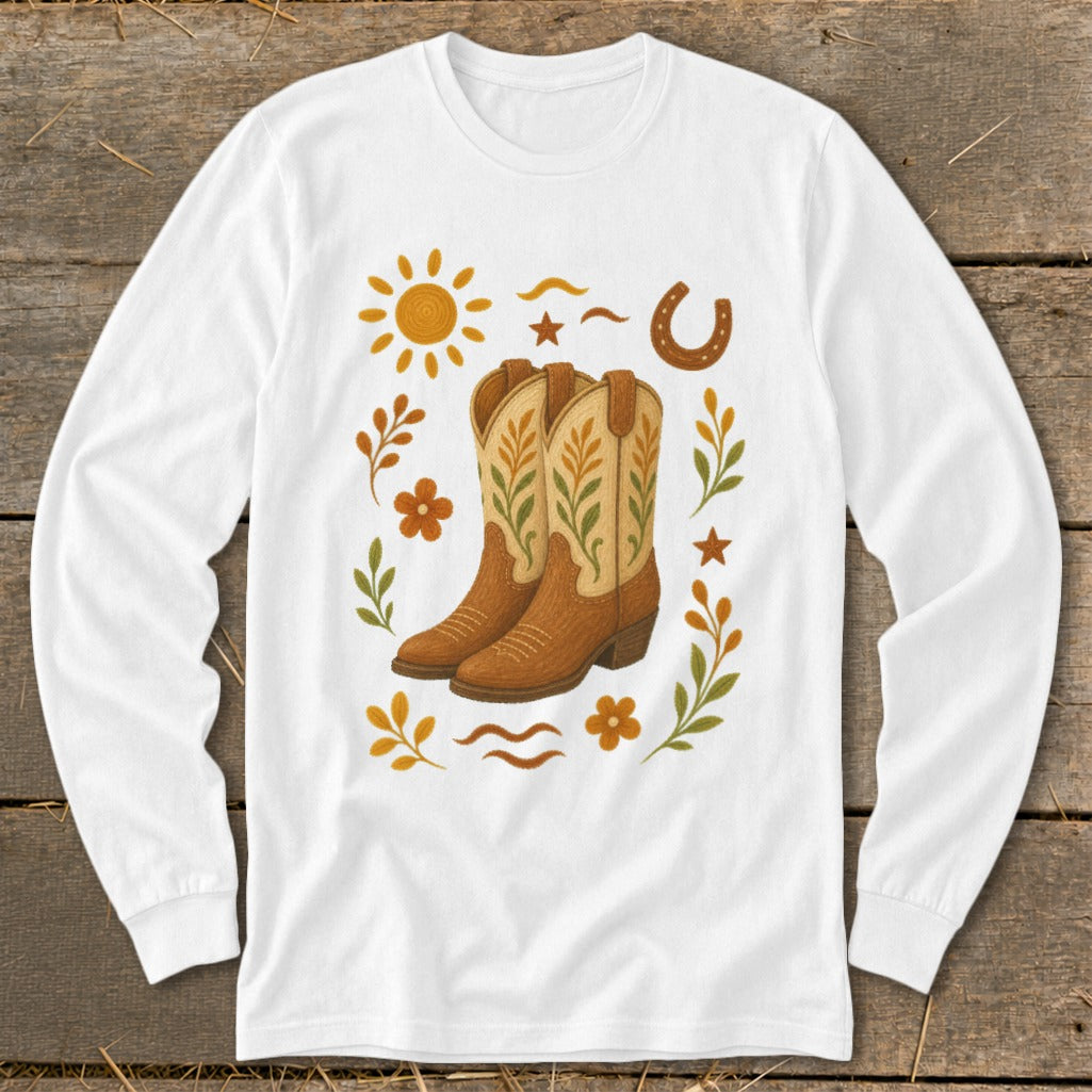 White long-sleeve shirt with cowboy boots, sun, horseshoe, and floral design.