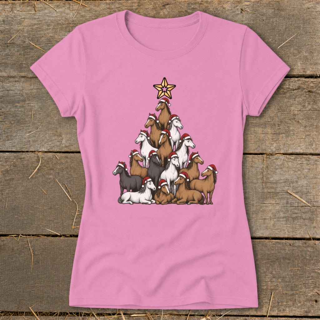 Horses wearing Santa hats form a Christmas tree shape topped with a star on a pink shirt.