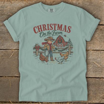 Boy feeding chickens in the snow with barn and text "Christmas On the Farm".