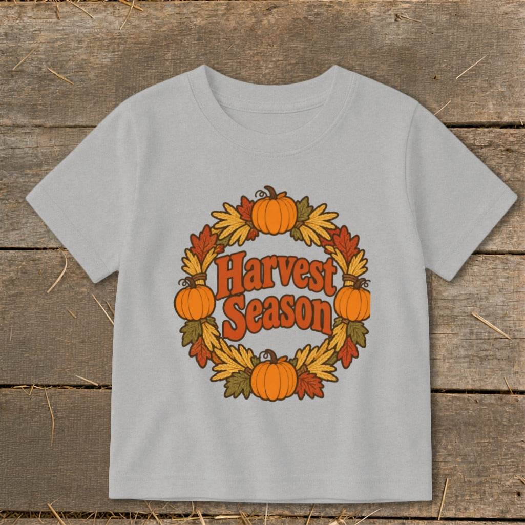 Light grey t-shirt with a circular harvest wreath featuring pumpkins and autumn leaves and the text "Harvest Season".