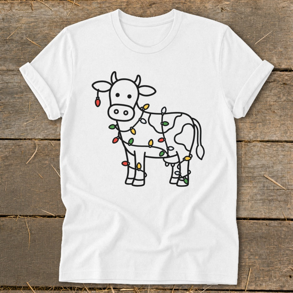 White t-shirt with a line drawing of a cow wrapped in colorful Christmas lights.