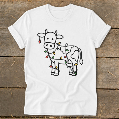 White t-shirt with a line drawing of a cow wrapped in colorful Christmas lights.