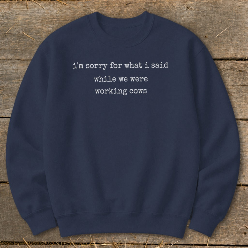 Navy sweatshirt with white text reading "i'm sorry for what i said while we were working cows."