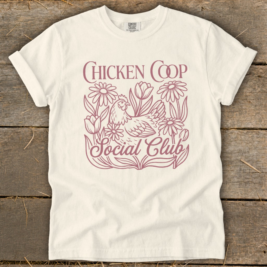 Cream t-shirt with "Chicken Coop Social Club" text and a chicken surrounded by flowers.