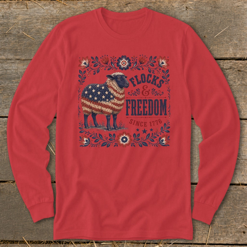 Sheep with American flag wool on red shirt with "Flocks & Freedom Since 1776" text.