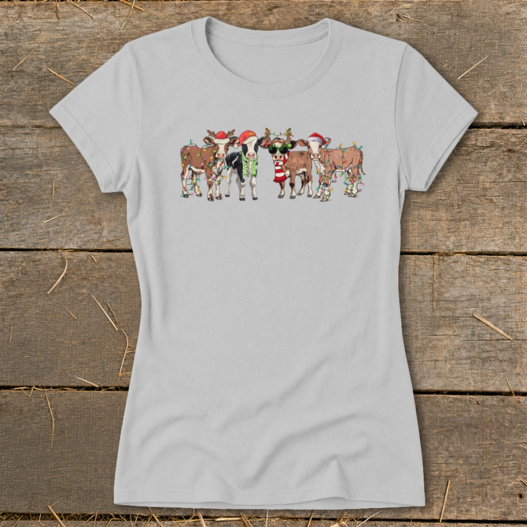 Group of cartoon cows wearing Santa hats and Christmas lights.