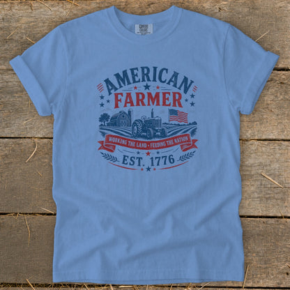 Light blue t-shirt with "American Farmer" graphic, tractor, barn, and flag.