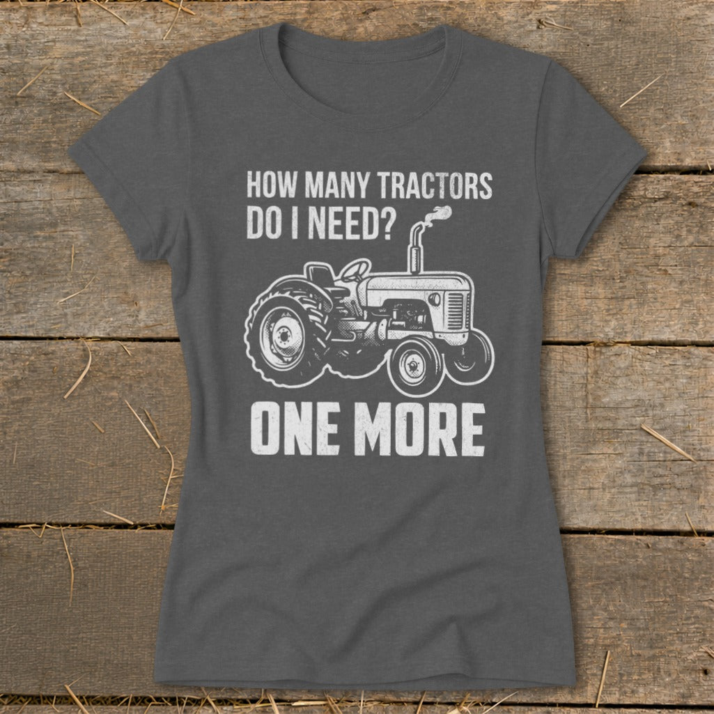Dark grey t-shirt with white text and tractor graphic: "How Many Tractors Do I Need? One More."
