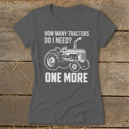Dark grey t-shirt with white text and tractor graphic: "How Many Tractors Do I Need? One More."