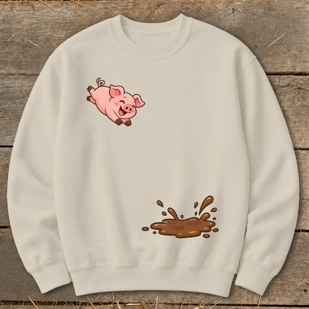 Cream sweatshirt with a cartoon pig jumping over a mud puddle graphic.