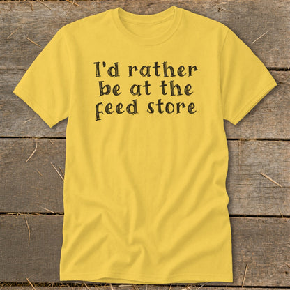 Yellow t-shirt with black text that reads "I'd rather be at the feed store".