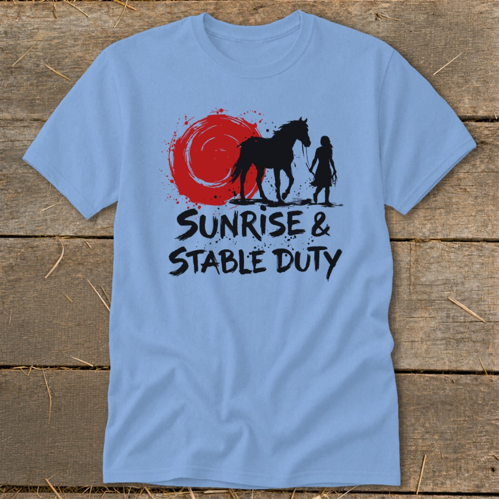 Light blue t-shirt with black graphic of horse and person under red sun, text reads "SUNRISE & STABLE DUTY".