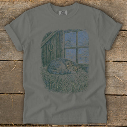 Gray t-shirt with illustration of a cat sleeping on hay by a snowy window.