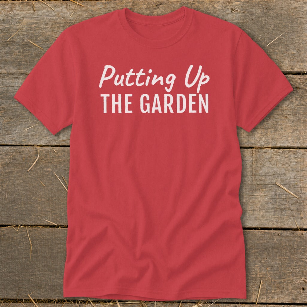 Red t-shirt with white text reading "Putting Up THE GARDEN".