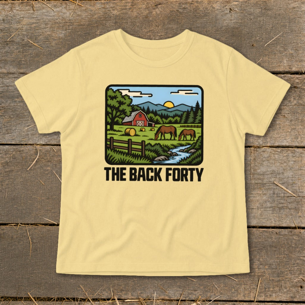A light yellow t-shirt featuring a cartoon rural farm landscape and the text THE BACK FORTY.