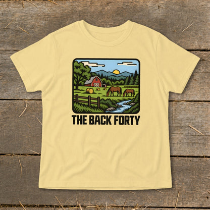 A light yellow t-shirt featuring a cartoon rural farm landscape and the text THE BACK FORTY.