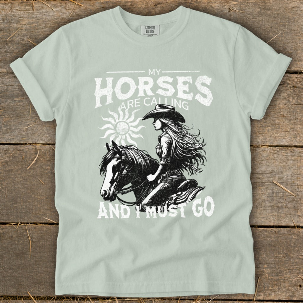 Graphic of a woman riding a horse with text "MY HORSES ARE CALLING AND I MUST GO".
