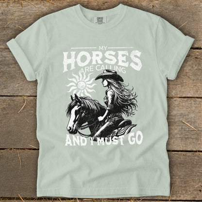 Graphic of a woman riding a horse with text "MY HORSES ARE CALLING AND I MUST GO".