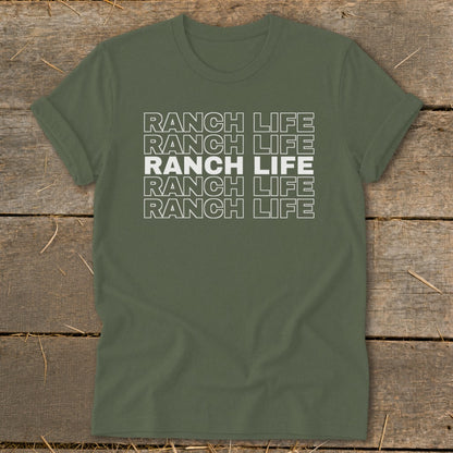 Olive green t-shirt laid flat on a wooden surface, featuring the repeated text Ranch Life in white.