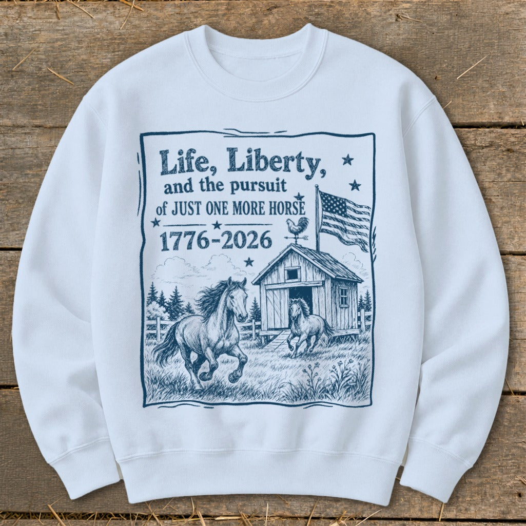 White sweatshirt with graphic: "Life, Liberty, and the pursuit of JUST ONE MORE HORSE 1776-2026".