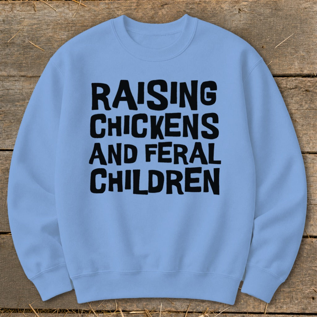 Light blue sweatshirt with black text: "RAISING CHICKENS AND FERAL CHILDREN."