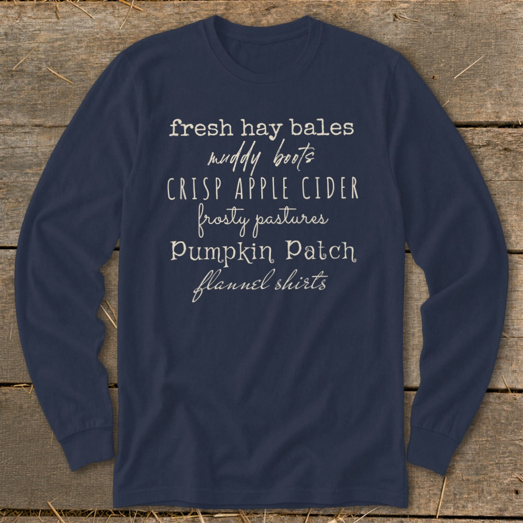 Navy long-sleeve shirt with "fresh hay bales, muddy boots, crisp apple cider, frosty pastures, pumpkin patch, flannel shirts" text.