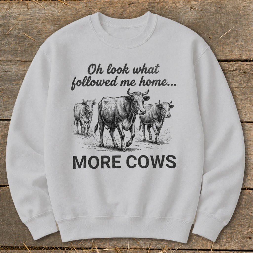 White sweatshirt with sketch of three cows and text "Oh look what followed me home... MORE COWS".
