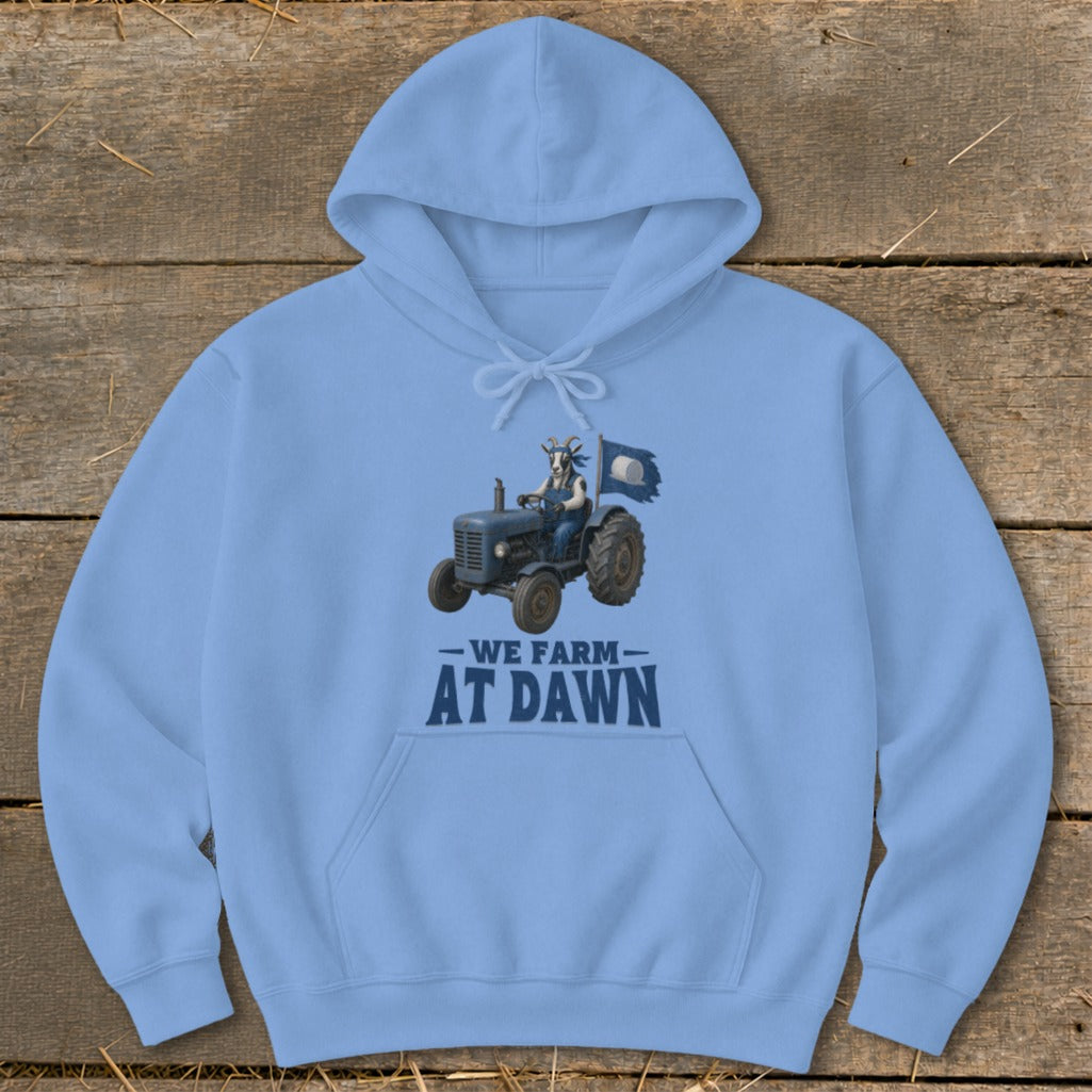 Light blue hoodie with graphic of a goat driving a tractor, text reads "We Farm At Dawn".